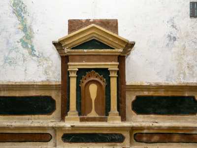 ...e un tabernacolo timpanato raffigurante un calice su sfondo rosso e nero